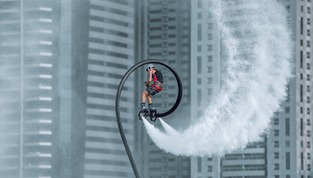 Man in Red Jacket Riding Bicycle on White Water Wave